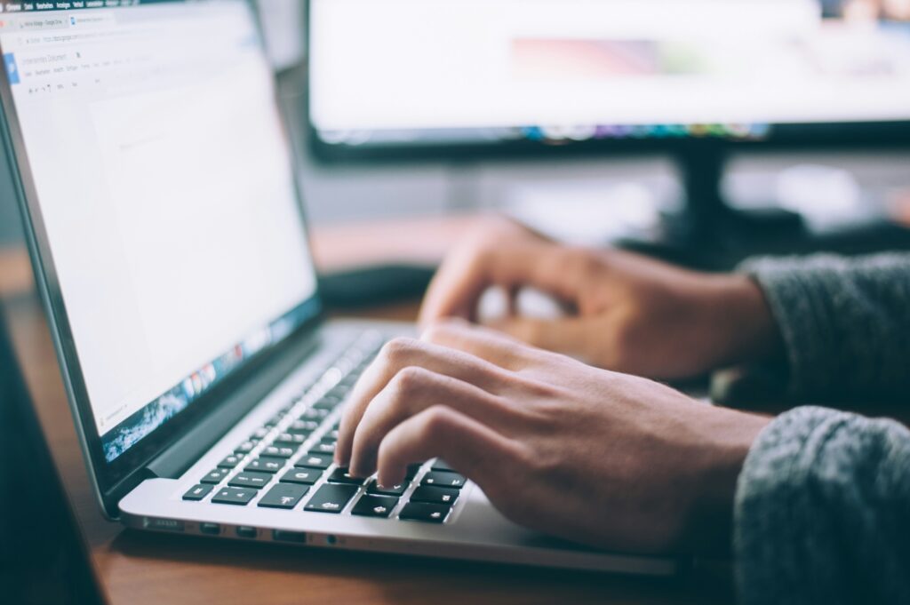Person's hands typing on laptop